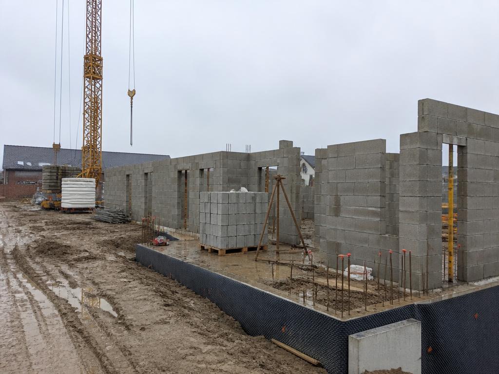 Ruwbouwwerf met betonblokken en wapeningsstaal in de Kempen
